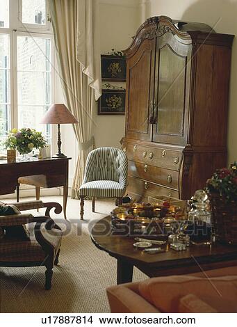 Antique linen press in traditional living room with tray of nightlights on antique table View Large Photo Image Picture - Antique linen press in traditional living room with tray of nightlights on antique table. Fotosearch