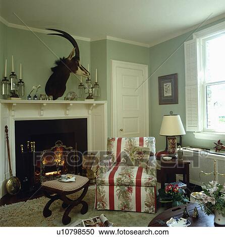 Armchair beside fireplace in traditional pastel green living room View Large Photo Image Stock Image - Armchair beside fireplace in traditional pastel green living room. Fotosearch