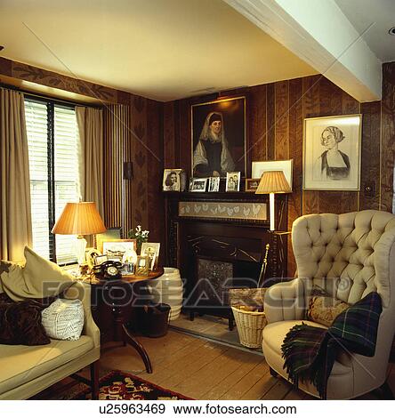 Stock Photo - Armchair beside fireplace in traditional living room. Fotosearch