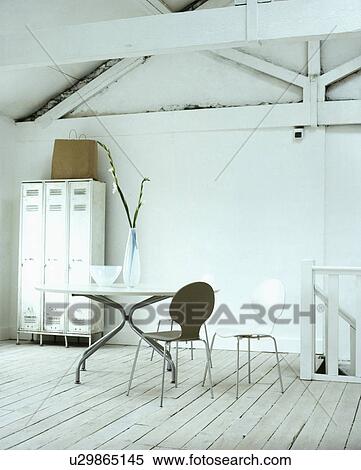 Arne Jacobsen 'Ant' chairs and metal table in white loft conversion with metal cupboard and white wooden flooring View Large Photo Image Stock Photography - Arne Jacobsen 'Ant' chairs and metal table in white loft conversion with metal cupboard and white wooden flooring. Fotosearch