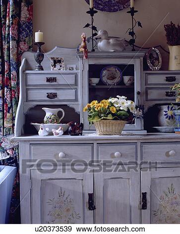 Basket of primulas on paint grey dresser with floral stencilling View Large Photo Image Stock Photo - Basket of primulas on paint grey dresser with floral stencilling. Fotosearch