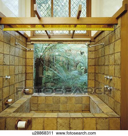 Bathroom with large tiled jacuzzi bath in front of window with view of garden View Large Photo Image Stock Image - Bathroom with large tiled jacuzzi bath in front of window with view of garden. Fotosearch