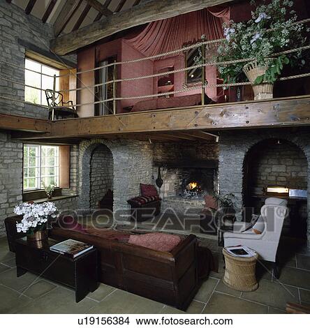 Picture - Bedroom on mezzanine above living room with large sofa in barn conversion. Fotosearch