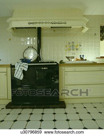 Stock Photograph Of Black Aga In Cream Kitchen With White Black Aga In Cream Kitchen With White Ceramic Floor Tiles