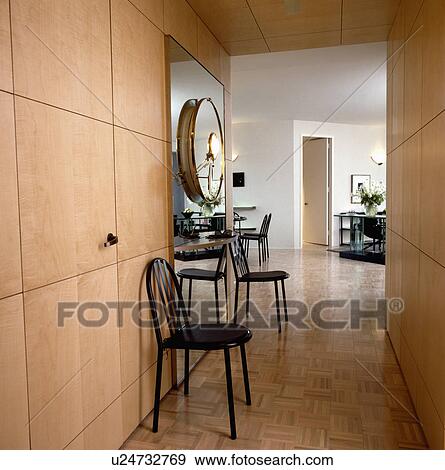 Black metal chairs and woodblock floor in neutral modern hall with wall of concealed storage cupboards View Large Photo Image Stock Photo - Black metal chairs and woodblock floor in neutral modern hall with wall of concealed storage cupboards. Fotosearch
