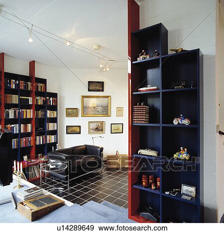 Stock Photo - Black shelves and black leather sofa in living room with black tiled floor. Fotosearch
