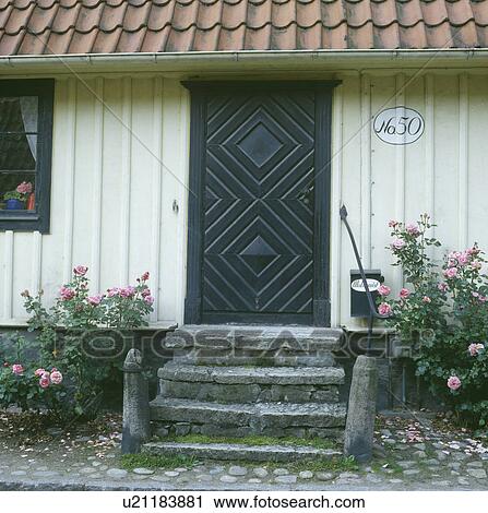 Black wooden door on traditional white single-storey cottage View Large Photo Image Stock Image - Black wooden door on traditional white single-storey cottage. Fotosearch