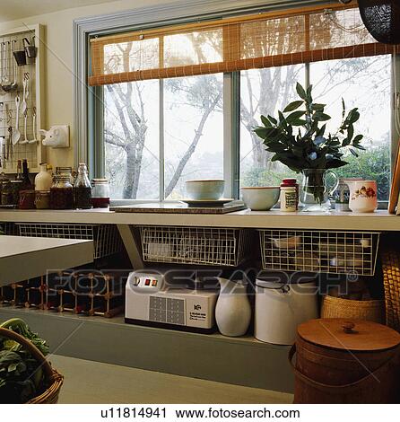 Blender base and enamel jug on shelf below window with split cane blind in economy style kitchen View Large Photo Image Stock Image - Blender base and enamel jug on shelf below window with split cane blind in economy style kitchen. Fotosearch