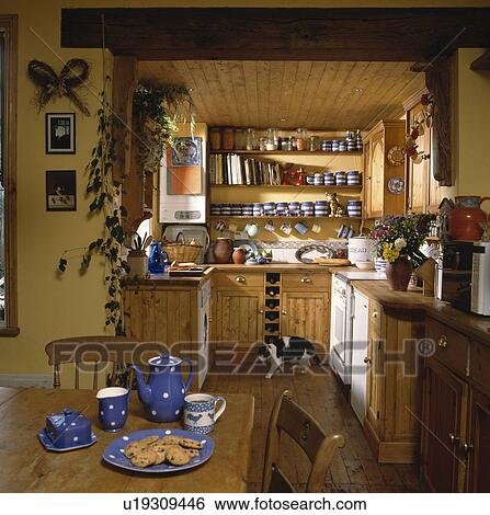 Blue and white spotted pottery on pine table in country kitchen with pine units and ceiling View Large Photo Image Stock Photograph - Blue and white spotted pottery on pine table in country kitchen with pine units and ceiling. Fotosearch