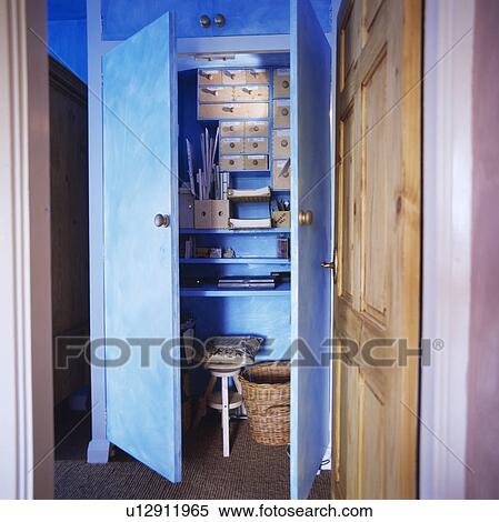 Blue cupboard doors open to reveal concealed home office View Large Photo Image Stock Photography - Blue cupboard doors open to reveal concealed home office . Fotosearch