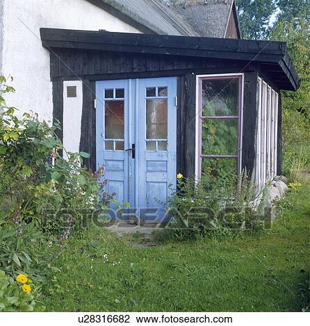 Blue double doors on porch extension on country cottage View Large Photo Image Stock Image - Blue double doors on porch extension on country cottage. Fotosearch