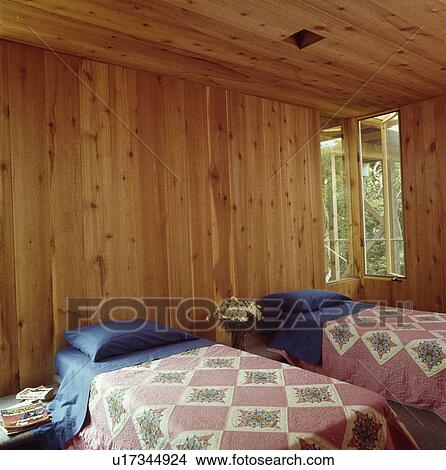 Blue Pillows And Pink Patchwork Quilts On Twin Beds In Log Cabin