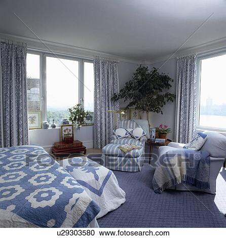 Blue+white quilts on bed and chest in bedroom with blue striped chaiselongue and blue carpet View Large Photo Image Stock Image - Blue+white quilts on bed and chest in bedroom with blue striped chaiselongue and blue carpet. Fotosearch
