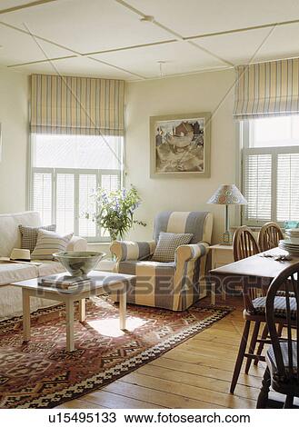 Blue+white striped armchair and striped blinds in coastal living room with rug on wooden floor View Large Photo Image Stock Image - Blue+white striped armchair and striped blinds in coastal living room with rug on wooden floor. Fotosearch