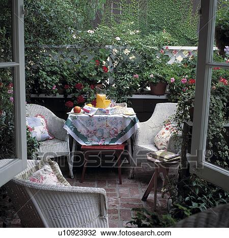 Breakfast set on a small terrace with pots of geraniums and ivy View Large Photo Image Stock Image - Breakfast set on a small terrace with pots of geraniums and ivy. Fotosearch