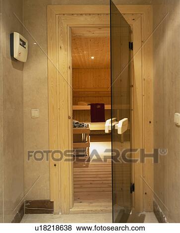 Stock Photo - Brown glass door open to modern sauna. Fotosearch