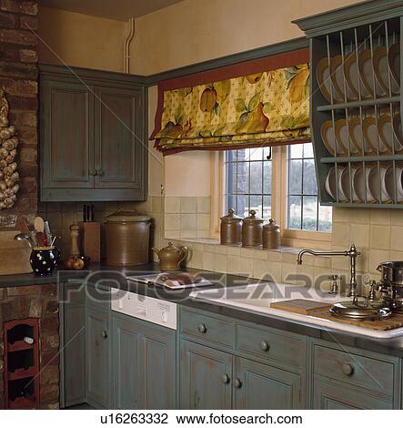 Built-in dishwasher and white sink in country kitchen with fruit-patterned blind and distressed paint effect cupboards View Large Photo Image Stock Image - Built-in dishwasher and white sink in country kitchen with fruit-patterned blind and distressed paint effect cupboards. Fotosearch