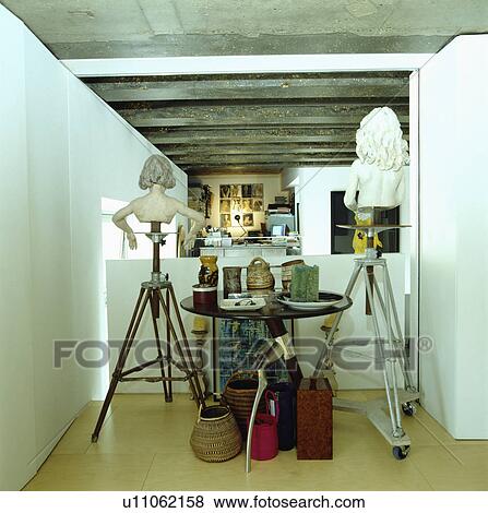Stock Photo - Busts displayed in studio along with other artifacts.. Fotosearch
