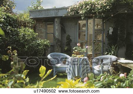 Cane furniture on patio in front of summerhouse in town garden View Large Photo Image Stock Image - Cane furniture on patio in front of summerhouse in town garden. Fotosearch