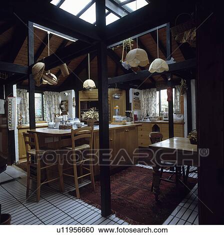 Cane lampshades in country kitchen with pine stools at breakfast bar View Large Photo Image Stock Image - Cane lampshades in country kitchen with pine stools at breakfast bar. Fotosearch