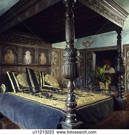 Carved oak Tudor four-poster bed with blue velvet bedcover embroidered with gold thread View Large Photo Image Stock Image - Carved oak Tudor four-poster bed with blue velvet bedcover embroidered with gold thread. Fotosearch