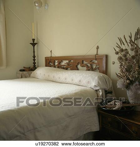 Carved wooden headboard on bed in neutral bedroom with cream bed linen View Large Photo Image Stock Image - Carved wooden headboard on bed in neutral bedroom with cream bed linen. Fotosearch