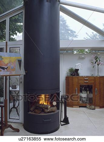 Stock Photography - Central cylindrical fireplace in studio.. Fotosearch