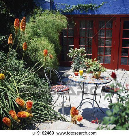 Chairs and table on patio in garden in summer View Large Photo Image Stock Photo - Chairs and table on patio in garden in summer. Fotosearch