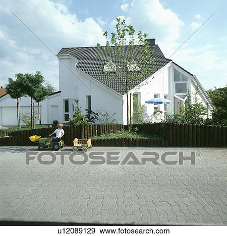 Stock Photo - Child on paved drive in front of modern white country house. Fotosearch