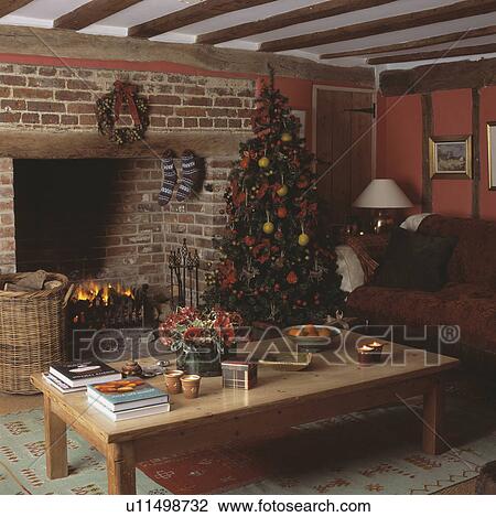 Stock Image - Christmas tree in red cottage living room. Fotosearch