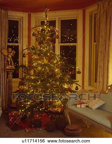 Stock Photograph - Christmas tree in window of traditional living room. Fotosearch