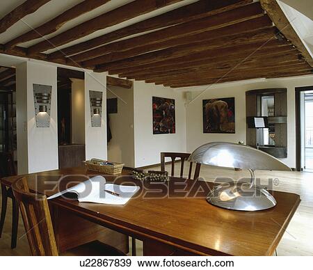 Stock Photo - Chrome Art Deco lamp on table in beamed traditional study. Fotosearch