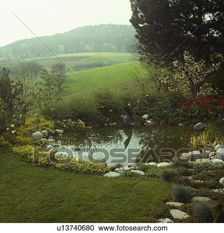 Stock Image - Circular pond in country garden. Fotosearch