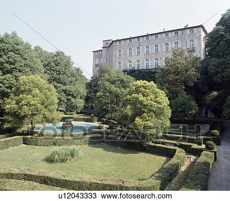 Stock Image - Clipped hedges enclosing lawn in formal garden in front of French chateau&#13; &#10;. Fotosearch