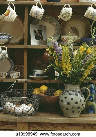 Close-up of basket of eggs and fresh flowers in spotted jug on pine dresser View Large Photo Image Stock Photo - Close-up of basket of eggs and fresh flowers in spotted jug on pine dresser. Fotosearch