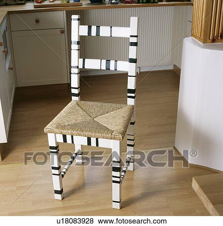 Stock Photo - Close-up of black and white geometric paint effect on wooden chair with rush seat. Fotosearch