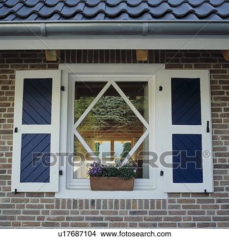 Picture - Close-up of blue+white shutters on traditional window. Fotosearch