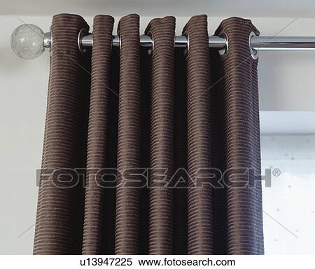 Stock Photography - Close-up of brown curtains on metal pole. Fotosearch