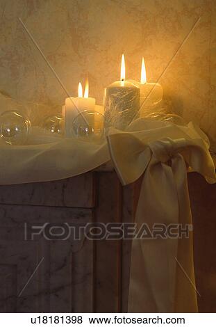 Close-up of candles and white silk bow on mantelpiece View Large Photo Image Stock Photo - Close-up of candles and white silk bow on mantelpiece. Fotosearch
