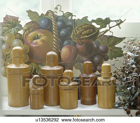 Stock Image - Close-up of collection of Treen bottles in front of picture of fruit. Fotosearch