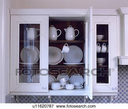 Close-up of collection of white jugs and china in white glass-fronted cupboard View Large Photo Image Stock Photo - Close-up of collection of white jugs and china in white glass-fronted cupboard. Fotosearch