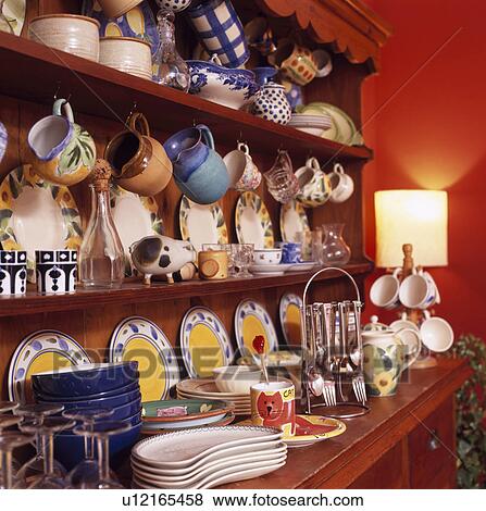 Close-up of colourful pottery jugs and plates and lighted lamp on dresser View Large Photo Image Stock Photo - Close-up of colourful pottery jugs and plates and lighted lamp on dresser. Fotosearch