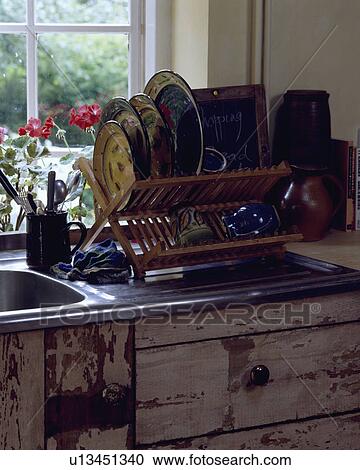 Close-up of colourful pottery plates on plate-rack on stainless steel drainingboard above reclaimed wood cupboard View Large Photo Image Stock Image - Close-up of colourful pottery plates on plate-rack on stainless steel drainingboard above reclaimed wood cupboard. Fotosearch