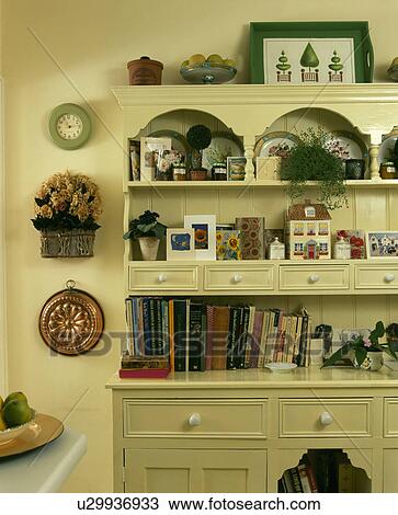 Stock Image - Close-up of cream dresser with books and cards. Fotosearch