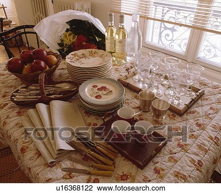Close-up of crockery and glasses with cutlery and napkins on quilted floral tablecloth View Large Photo Image Stock Image - Close-up of crockery and glasses with cutlery and napkins on quilted floral tablecloth. Fotosearch