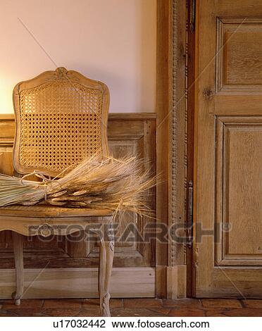 Close-up of dried grasses on antique chair beside old carved wooden door View Large Photo Image Stock Image - Close-up of dried grasses on antique chair beside old carved wooden door. Fotosearch
