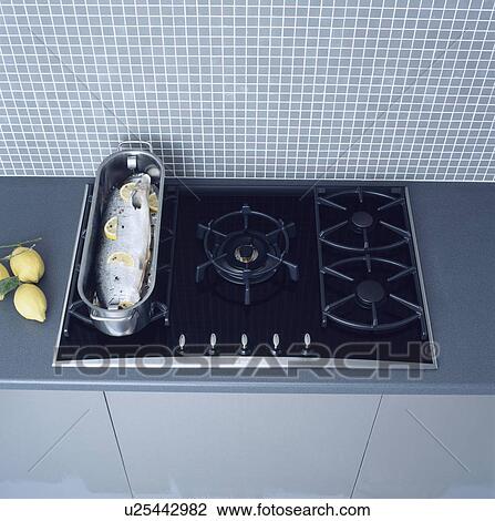 Stock Image - Close-up of fish in metal fishkettle on black gas hob&#13; &#10; &#13; &#10; &#13; &#10; &#13; &#10; &#13; &#10; &#13; &#10;. Fotosearch