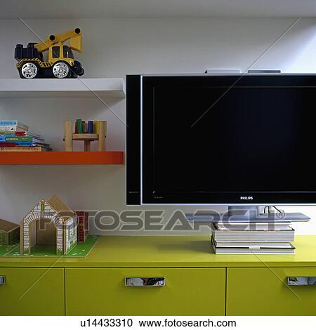 Close up of flat screen television on lime green storage cupboards in modern playroom View Large Photo Image Stock Image - Close up of flat screen television on lime green storage cupboards in modern playroom. Fotosearch