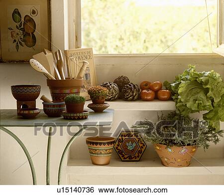 Stock Photograph - Close-up of houseplants and vegetables in painted terracotta pots. Fotosearch