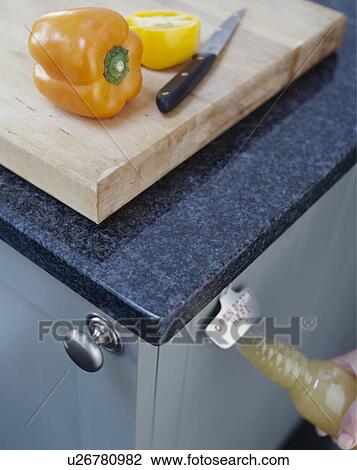 Close Up Of Knife And Yellow Pepper On Wooden Chopping Board On